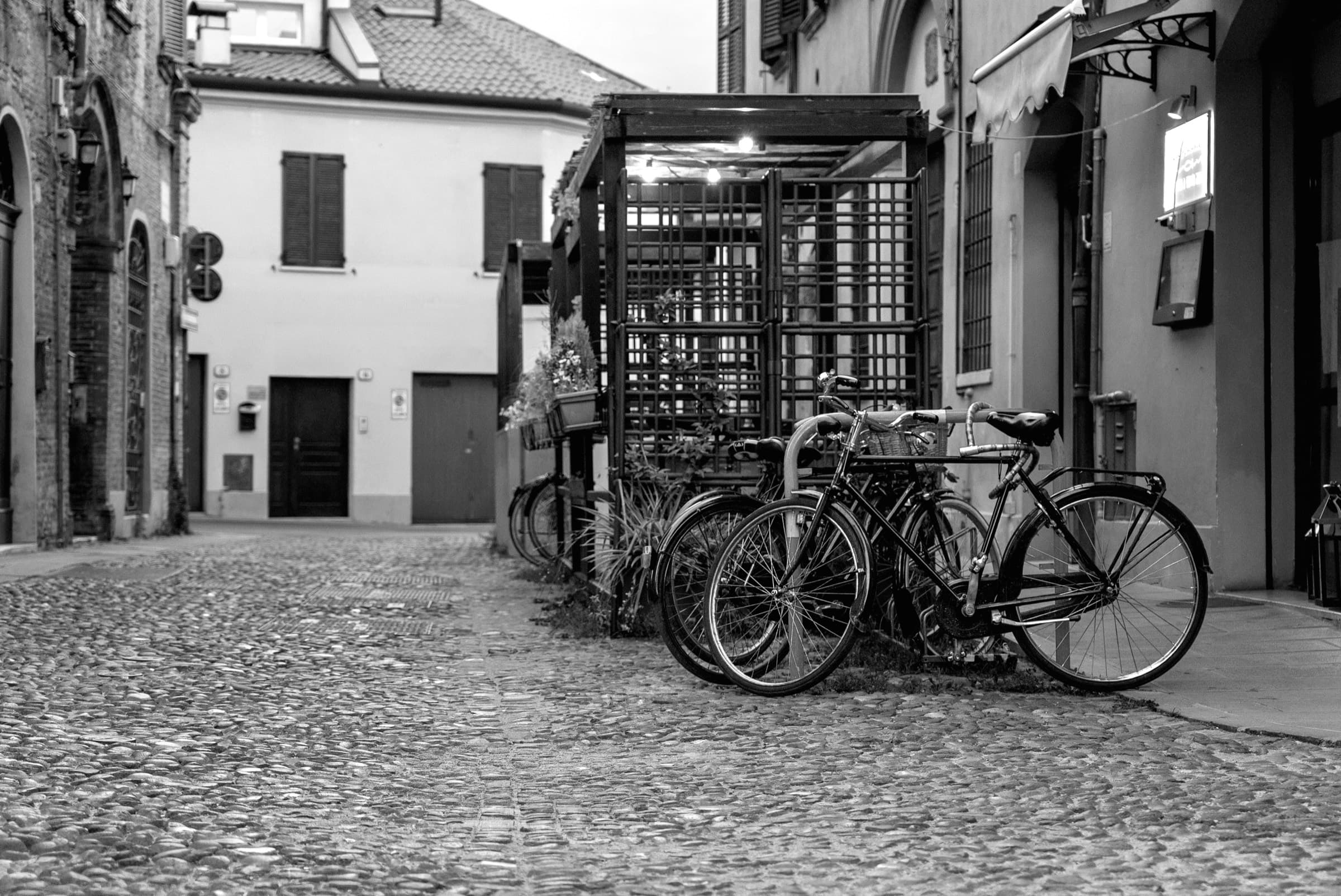 Fahrräder vor der Terrasse der Trattoria Le Nuvole, in Schwarz-Weiß