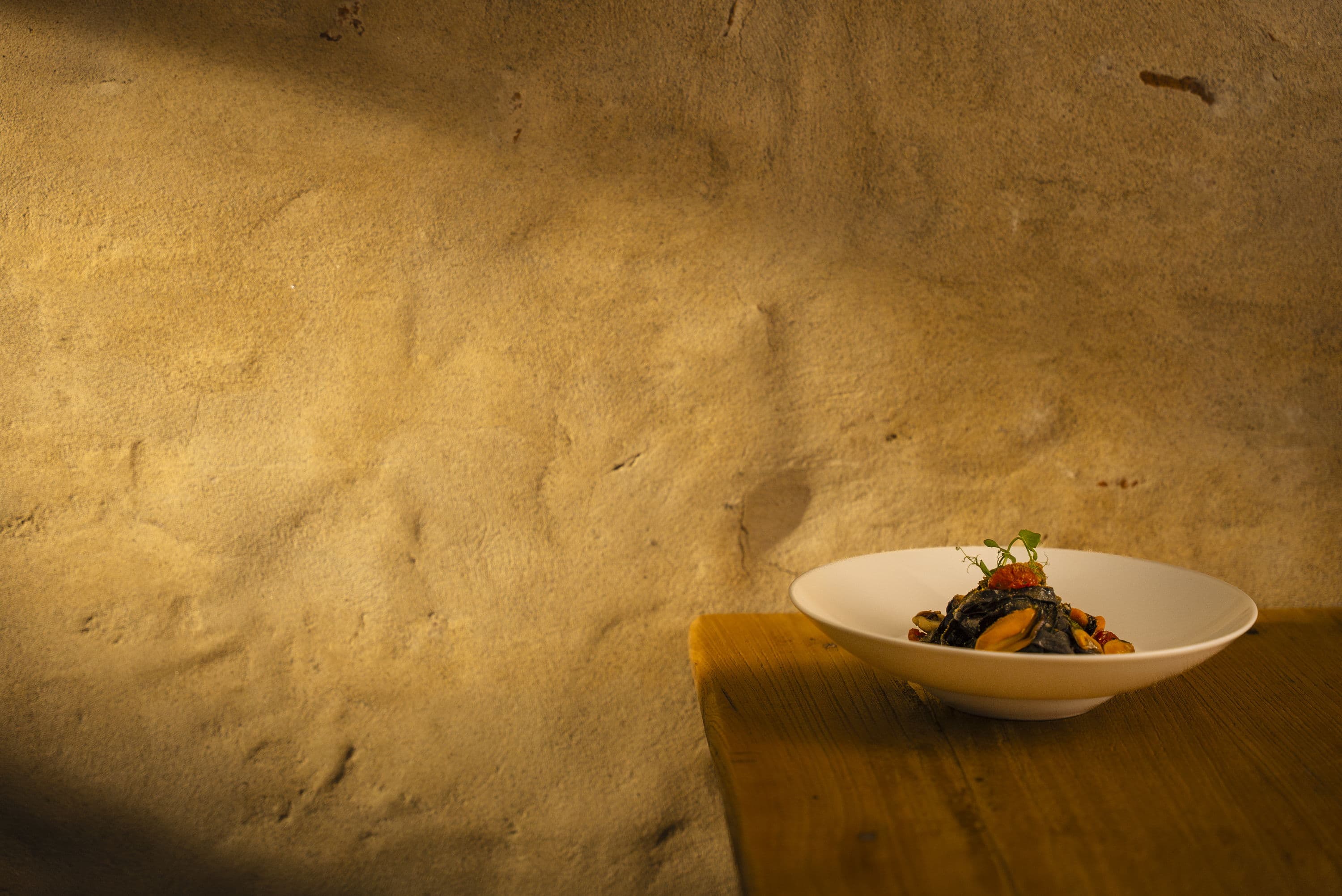 Squid ink tagliatelle with mussels on a wooden table
